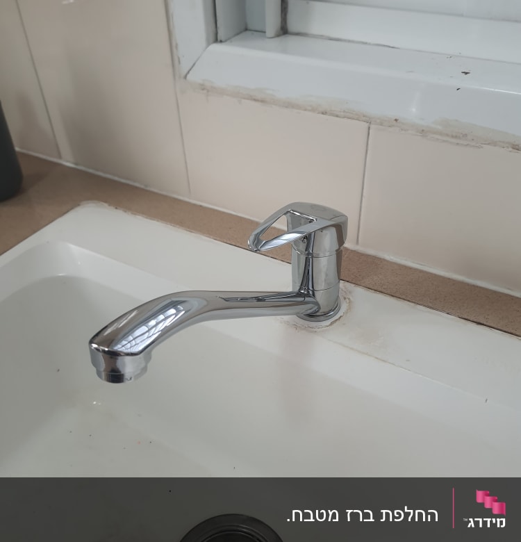 ברז כרום מותקן בכיור לבן עם ניקוז מתכת